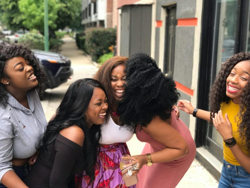 A joyful group of friends sharing a moment of laughter on a sunny day outdoors.